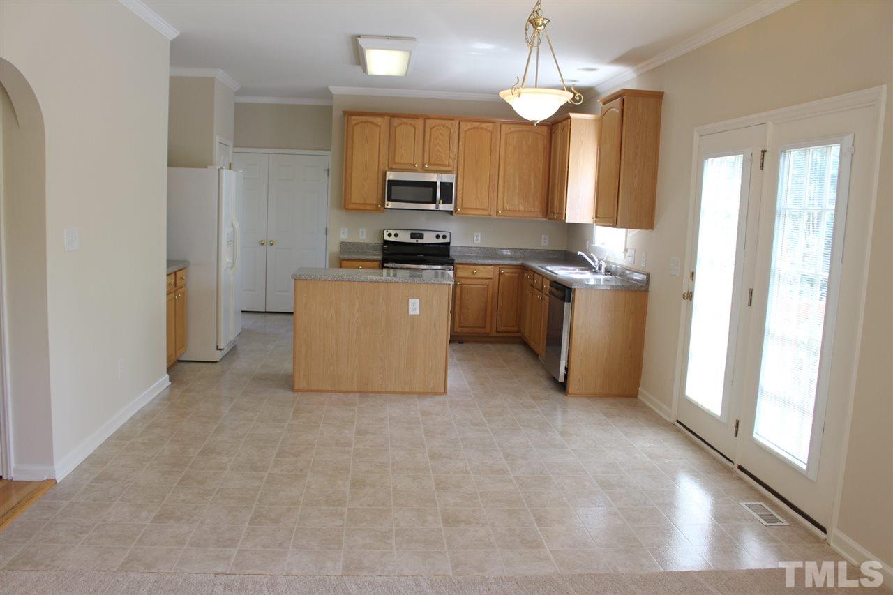 1817 White Dogwood Road Apex, NC 27502 - Photo 6 of 13 a kitchen with kitchen island granite countertop a stove top oven a sink a counter top space and cabinets