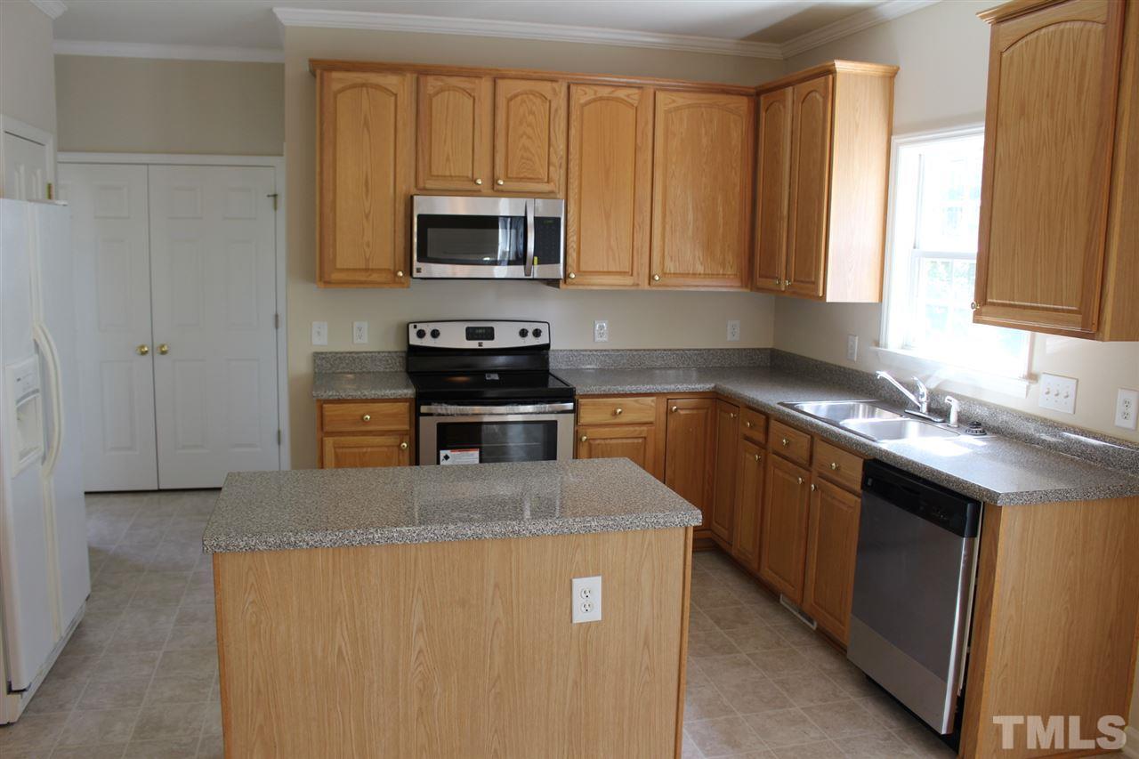 1817 White Dogwood Road Apex, NC 27502 - Photo 7 of 13 a kitchen with stainless steel appliances granite countertop a sink stove microwave and refrigerator