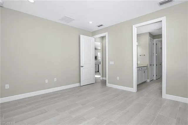 a view of an empty room with wooden floor and closet