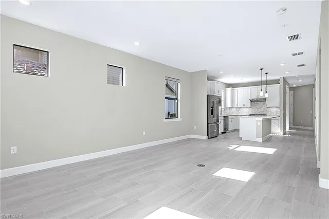 a view of a big room with wooden floor and windows