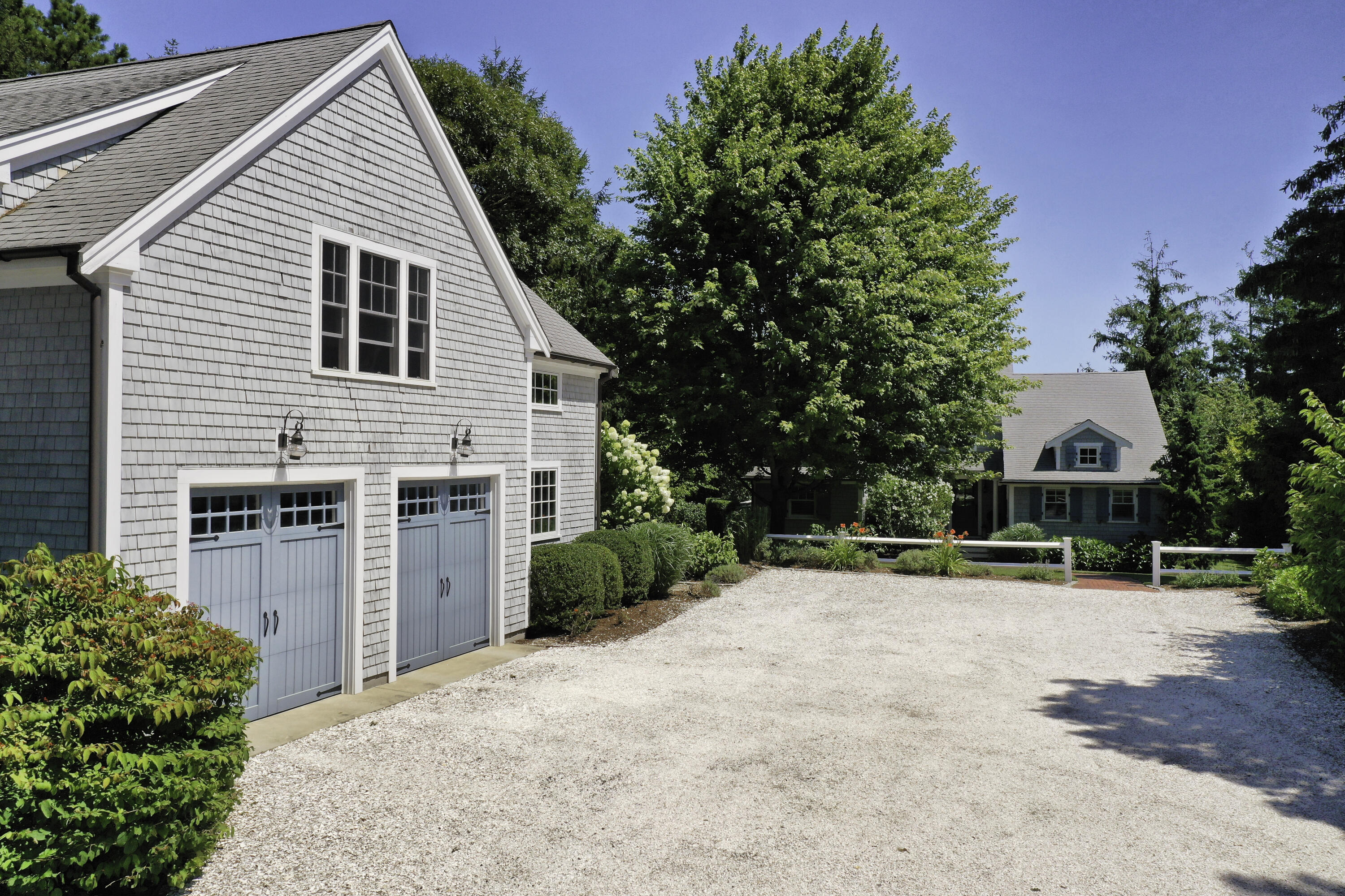 a view of a white house with a yard and potted plants