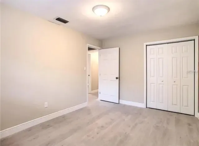 an empty room with closet and a window