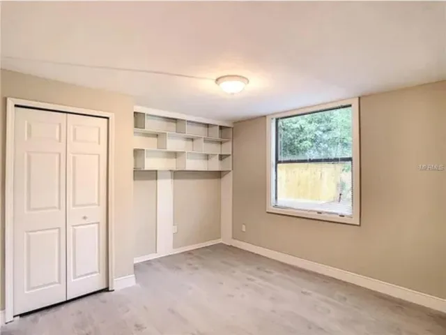 an empty room with windows and closet
