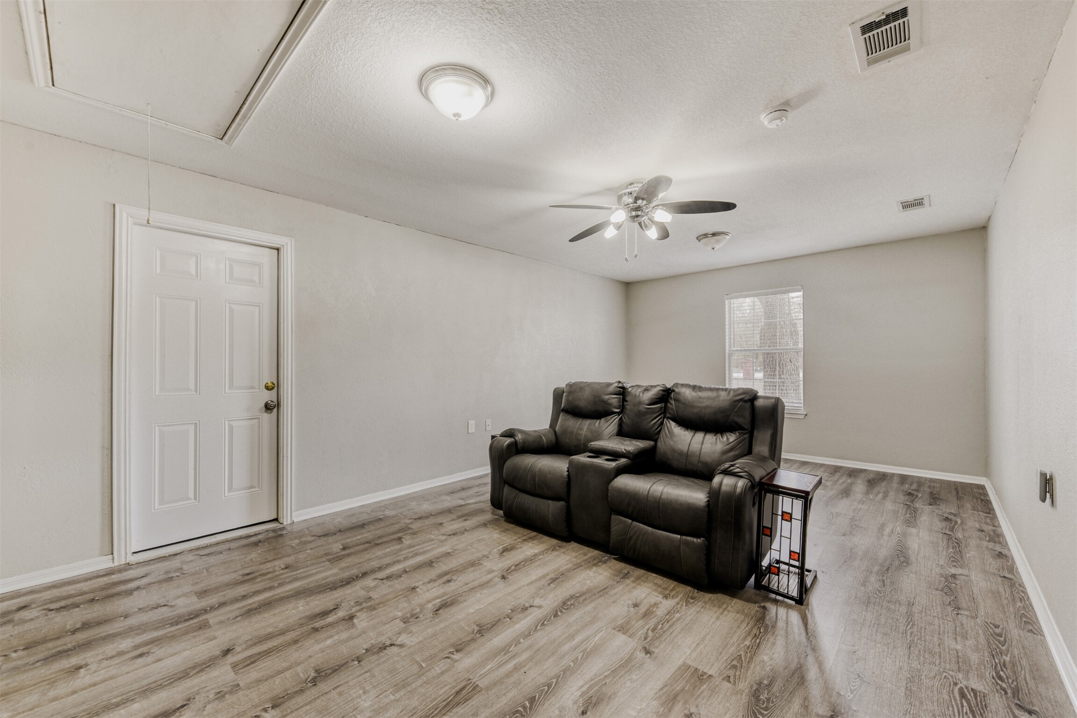 104 Spring Branch Bastrop, TX 78602 - Photo 21 of 32 Cinema featuring a textured ceiling, light wood-style flooring, and a ceiling fan