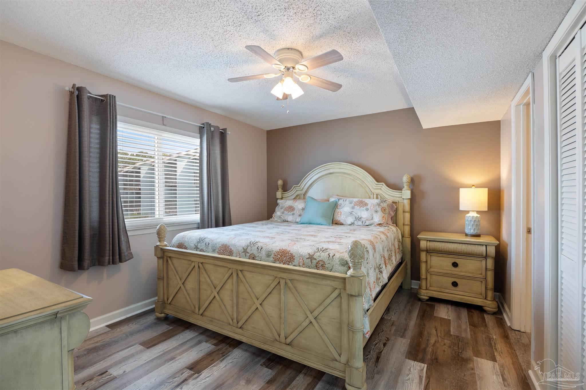 14100 River Road, Unit 228B Pensacola, FL 32507 - Photo 14 of 41 a bedroom with a bed and a chandelier