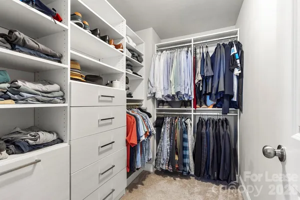 a view of walk in closet with clothes and shoes