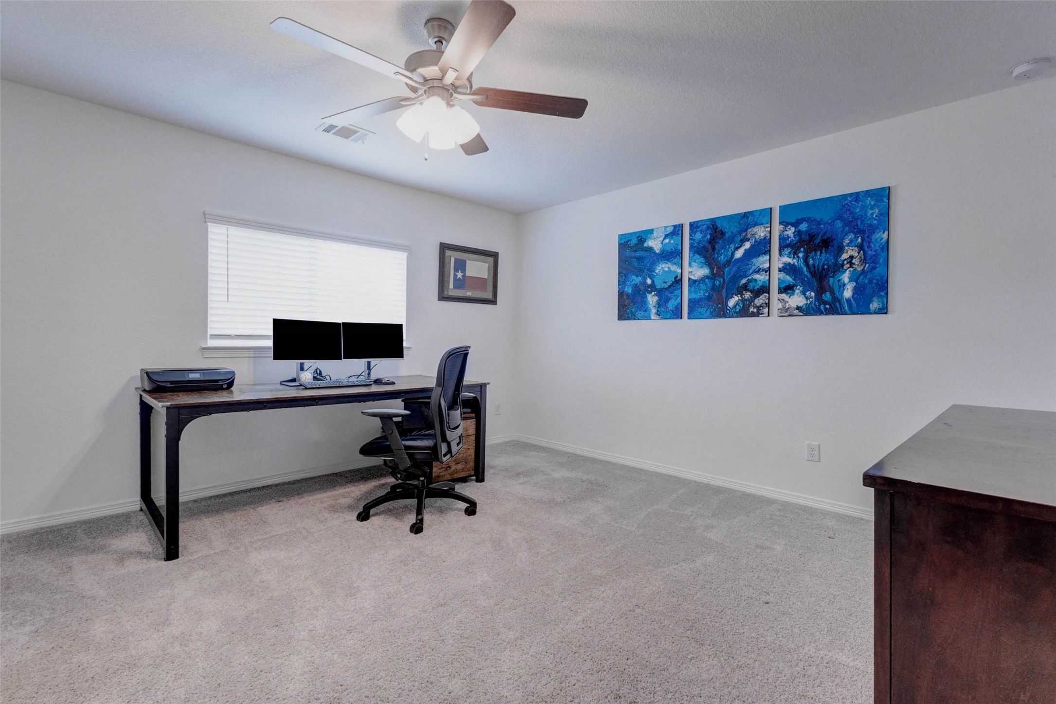 32418 Fly Fish Way Fulshear, TX 77441 - Photo 28 of 40 The first of three upstairs guest bedrooms is a versatile and well-appointed space, currently serving as a home office. Plush carpet, a ceiling fan, and a large window filling the room with natural light make it equally well suited as a bedroom, study, or flex space to fit your needs.