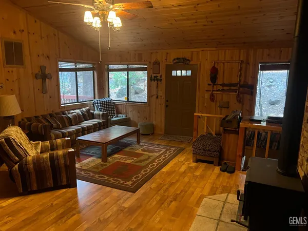 a living room with furniture a dining table and a refrigerator