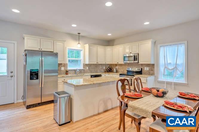 2508 Buck Island Road Charlottesville, VA 22902 - Photo 4 of 23 a kitchen with stainless steel appliances granite countertop a refrigerator a sink a stove a dining table and chairs