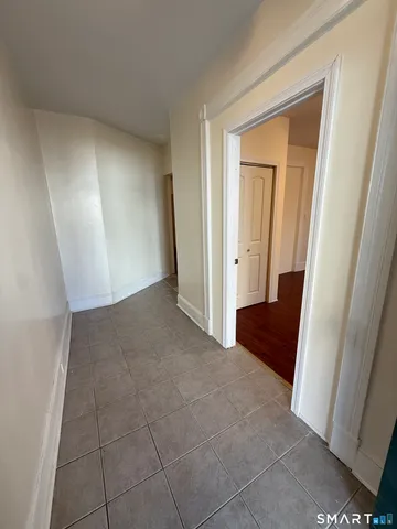 an empty room with a wooden door and mirror