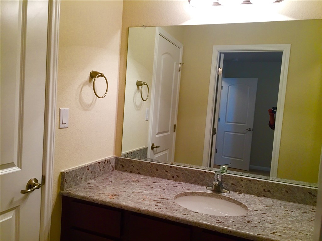 3451 Mayfield Ranch Boulevard, Unit 703 Round Rock, TX 78681 - Photo 17 of 23 a bathroom with a granite countertop sink and a mirror