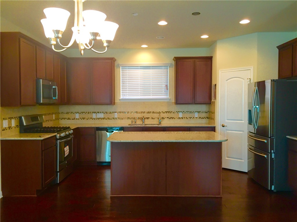 3451 Mayfield Ranch Boulevard, Unit 703 Round Rock, TX 78681 - Photo 6 of 23 a kitchen with stainless steel appliances granite countertop a sink stove and refrigerator