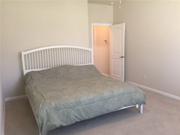 a bed sitting in a bedroom next to a window