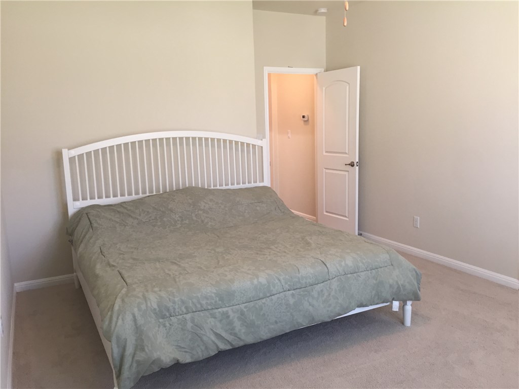 3451 Mayfield Ranch Boulevard, Unit 703 Round Rock, TX 78681 - Photo 8 of 23 a bed sitting in a bedroom next to a window