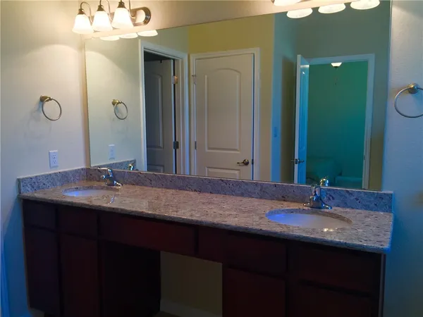 a bathroom with a double vanity sink and a mirror