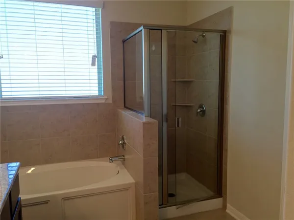 a bathroom with a shower and a bath tub