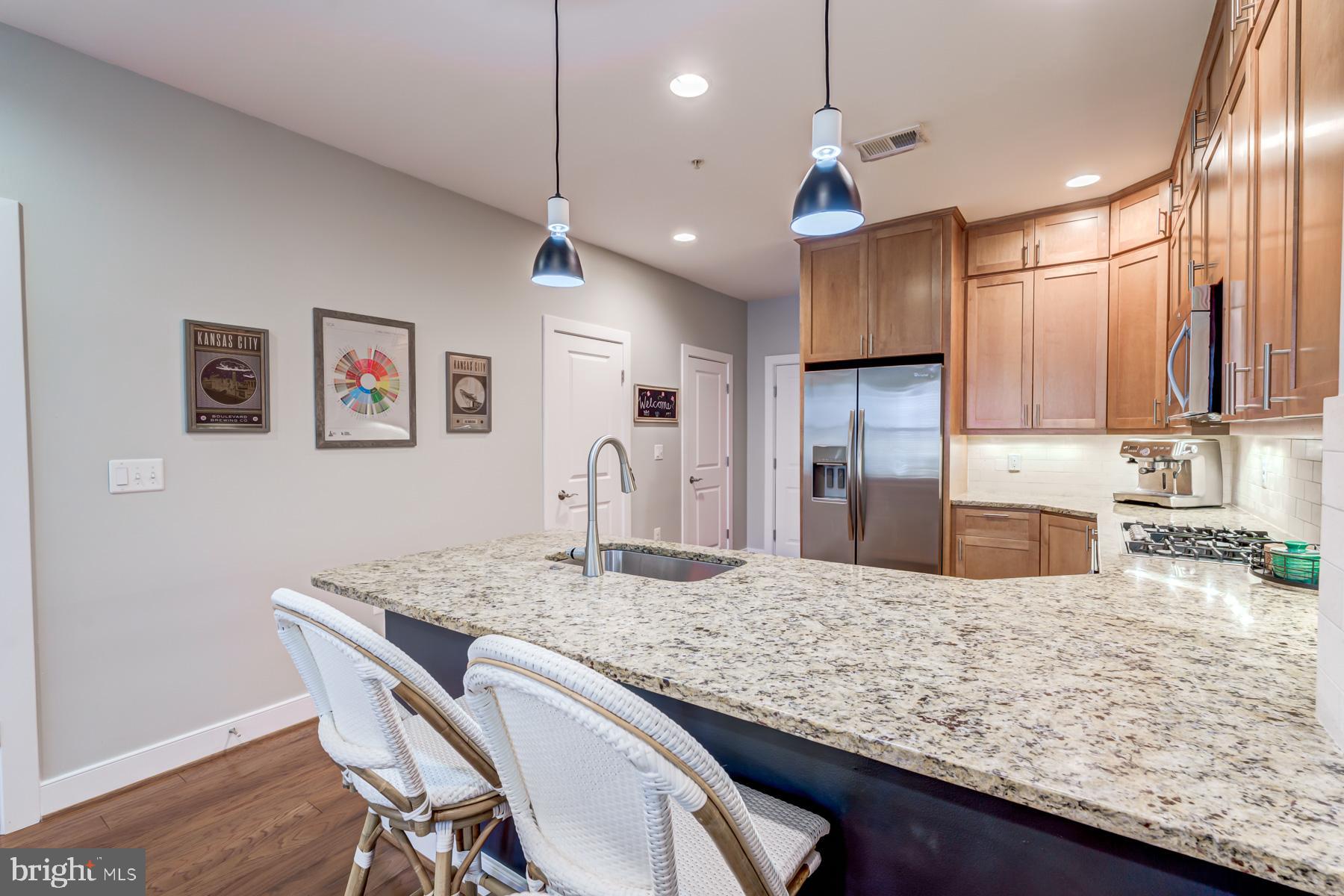 2207 Main Line Boulevard, Unit 101 Alexandria, VA 22301 - Photo 10 of 46 a kitchen with granite countertop kitchen island stainless steel appliances a sink stove and refrigerator