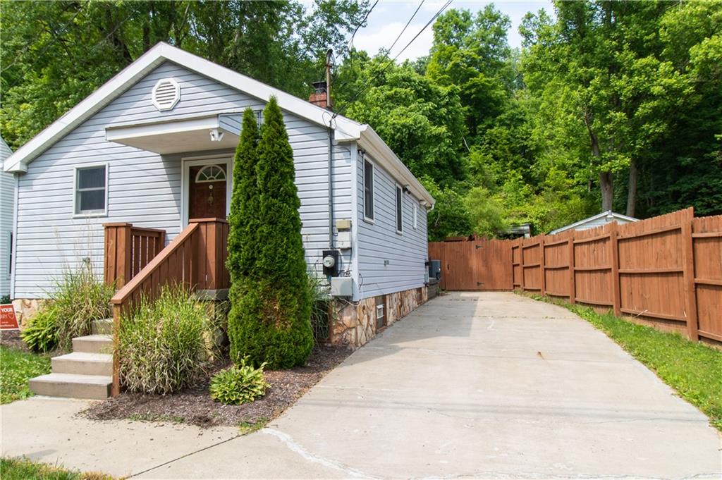 2111 Lewis Run Road Clairton, PA 15025 - Photo 3 of 17 a view of a white house with a small yard plants and large tree