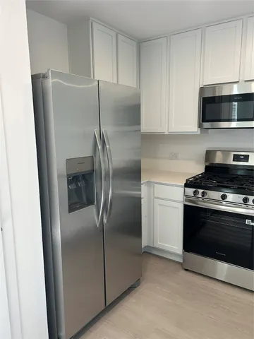 a kitchen with stainless steel appliances granite countertop a refrigerator and a stove top oven