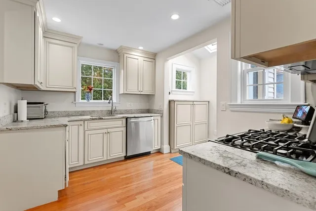 a kitchen with granite countertop a stove top oven a sink a counter space and cabinets