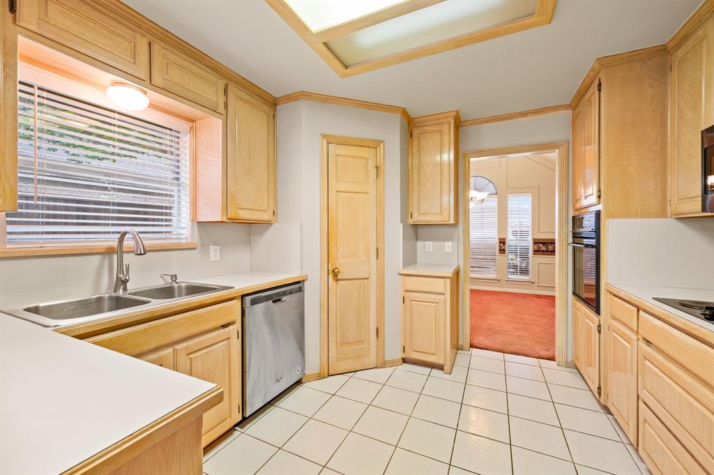 924 Hardie Street Hurst, TX 76053 - Photo 15 of 32 a kitchen with stainless steel appliances a refrigerator sink and cabinets