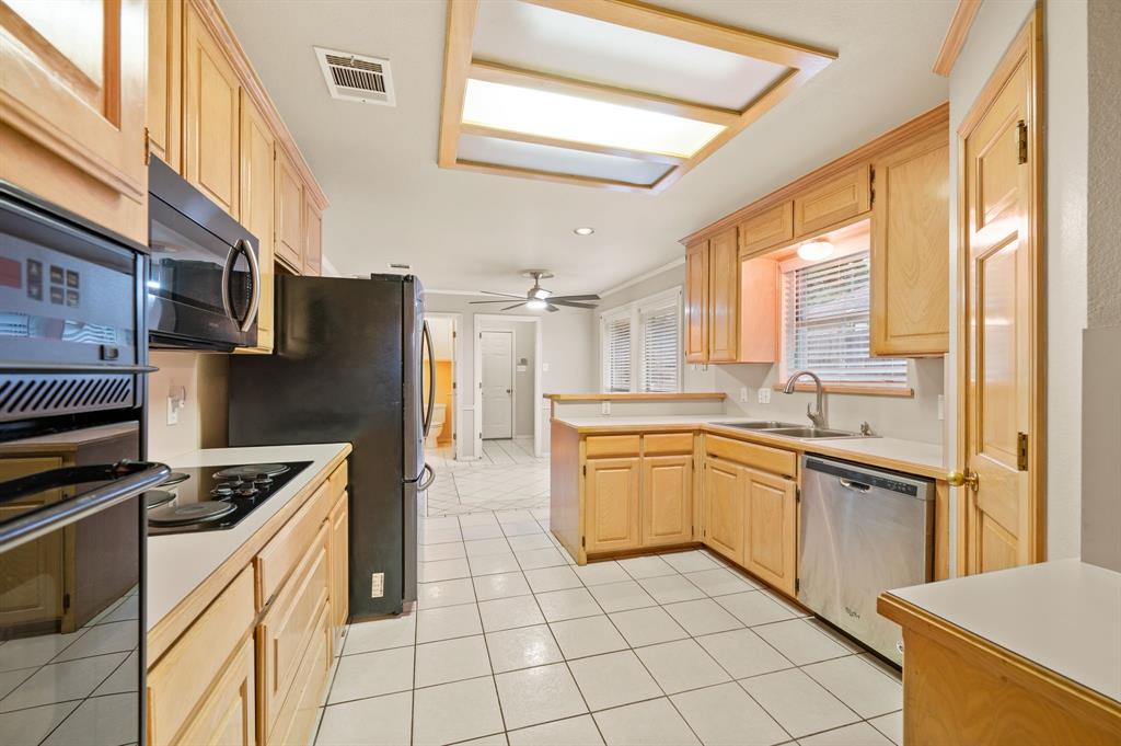 924 Hardie Street Hurst, TX 76053 - Photo 4 of 32 a kitchen with stainless steel appliances granite countertop a stove a sink and a refrigerator
