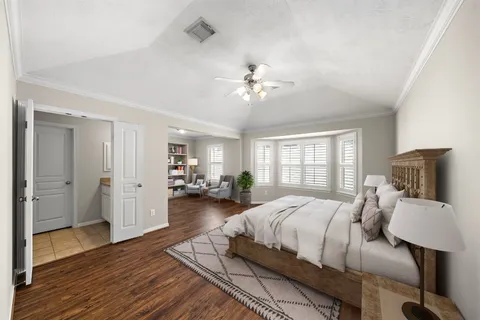 a spacious bedroom with a bed and wooden floor