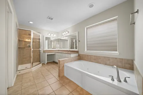 a bathroom with a tub sink shower and mirror