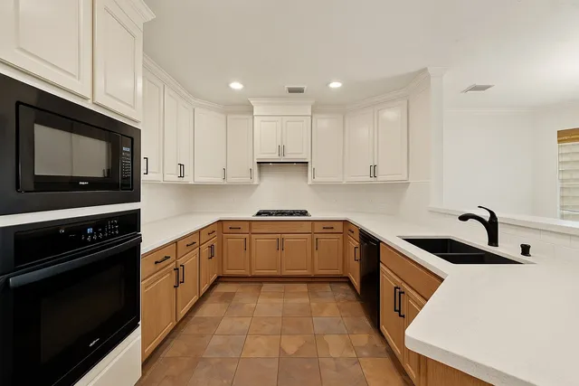 a kitchen with stainless steel appliances granite countertop a sink and a stove top oven with white cabinets