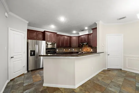 a kitchen with stainless steel appliances granite countertop a refrigerator and a stove