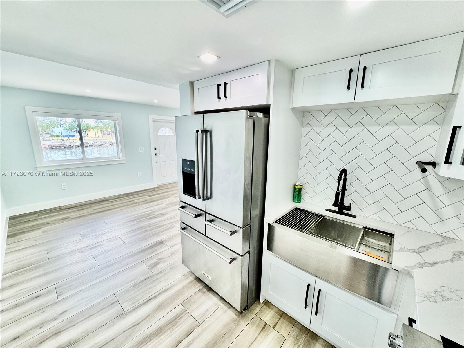 2415 Northwest 16th St Road, Unit 101 Miami, FL 33125 - Photo 14 of 36 a kitchen with stainless steel appliances a refrigerator sink and cabinets