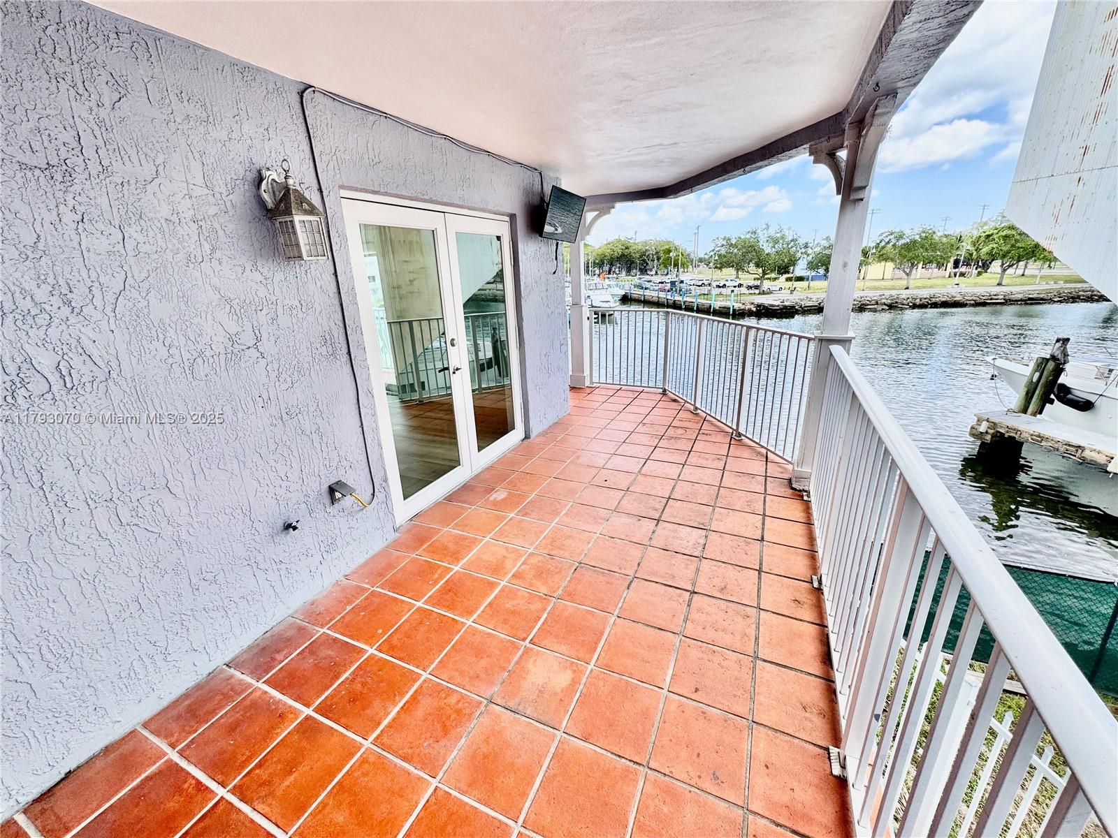 2415 Northwest 16th St Road, Unit 101 Miami, FL 33125 - Photo 21 of 36 a view of balcony with wooden floor and fence