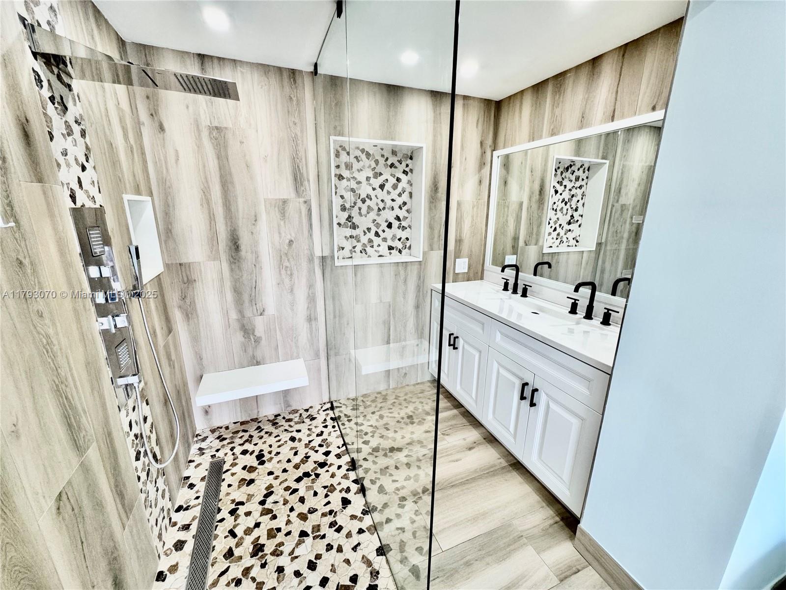2415 Northwest 16th St Road, Unit 101 Miami, FL 33125 - Photo 22 of 36 a bathroom with a double vanity sink and a shower