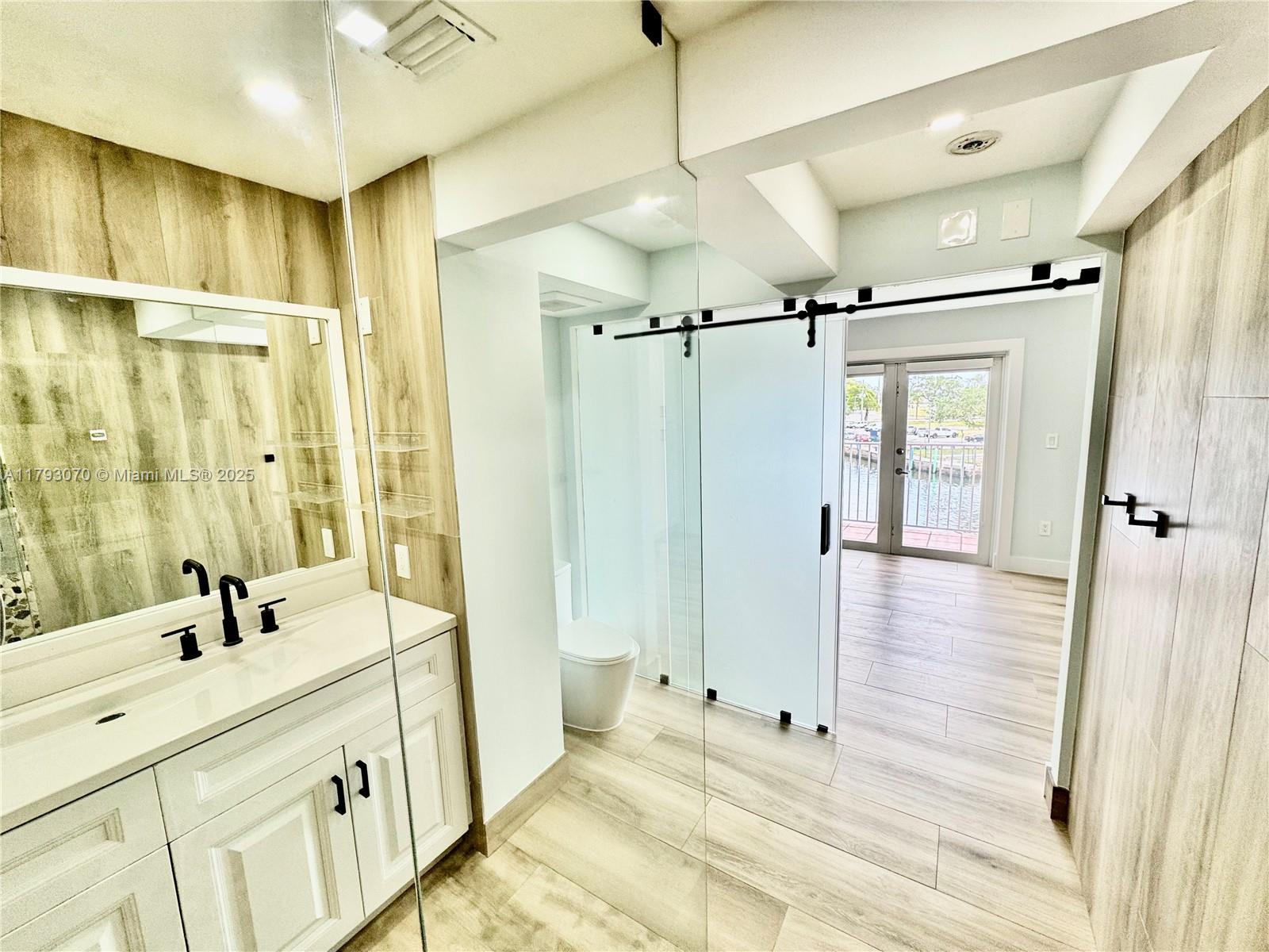 2415 Northwest 16th St Road, Unit 101 Miami, FL 33125 - Photo 24 of 36 a bathroom with a double vanity sink mirror double and shower