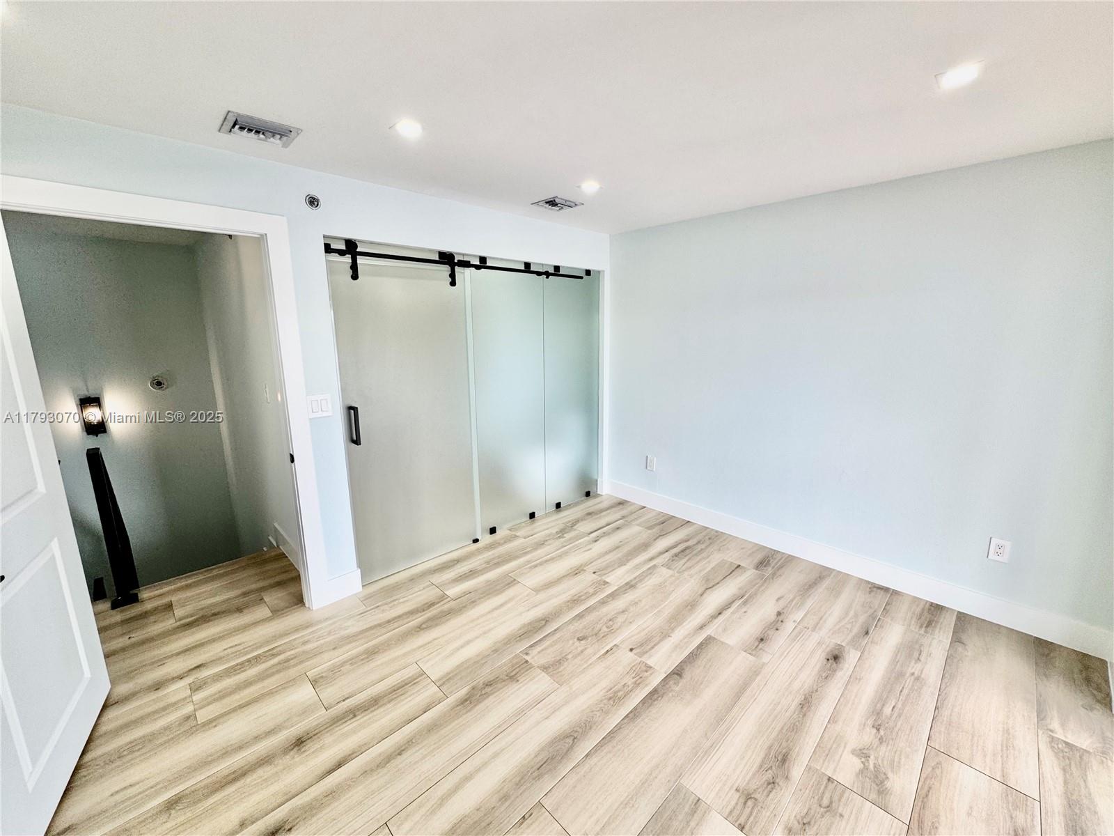 2415 Northwest 16th St Road, Unit 101 Miami, FL 33125 - Photo 27 of 36 a view of a room with wooden floor and bathroom