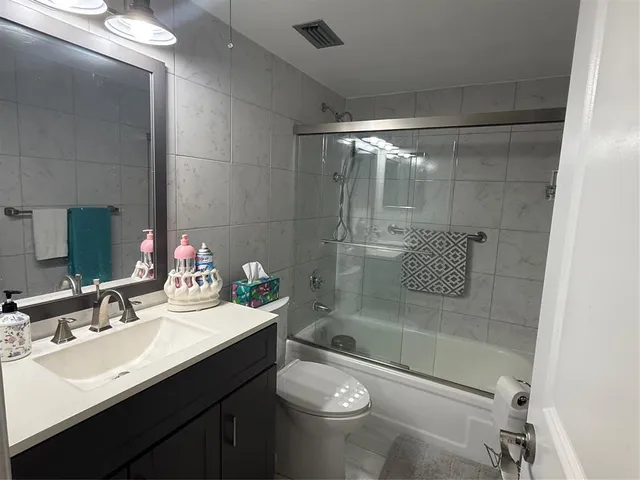 a bathroom with a sink mirror toilet and shower
