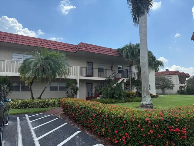 a front view of a house with a yard and potted plants