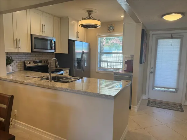 a kitchen with granite countertop a sink a stove and microwave