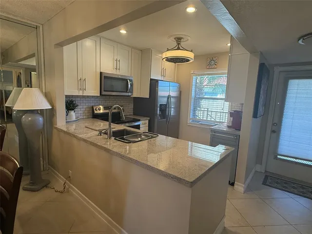 a kitchen with a sink appliances and cabinets