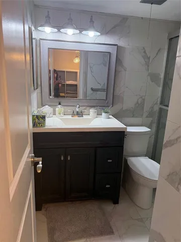 a bathroom with a sink vanity and toilet