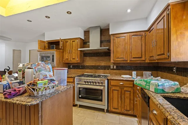 a kitchen with stainless steel appliances granite countertop a stove and cabinets