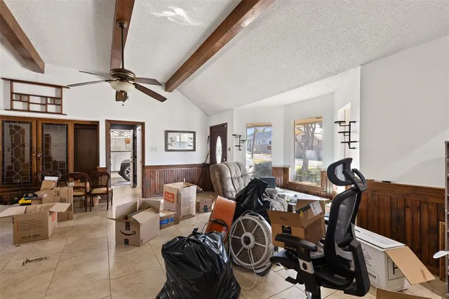 a living room with furniture a chandelier fan and a window