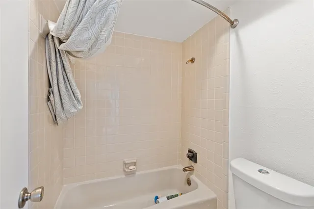 an empty room with windows and ceiling fan view