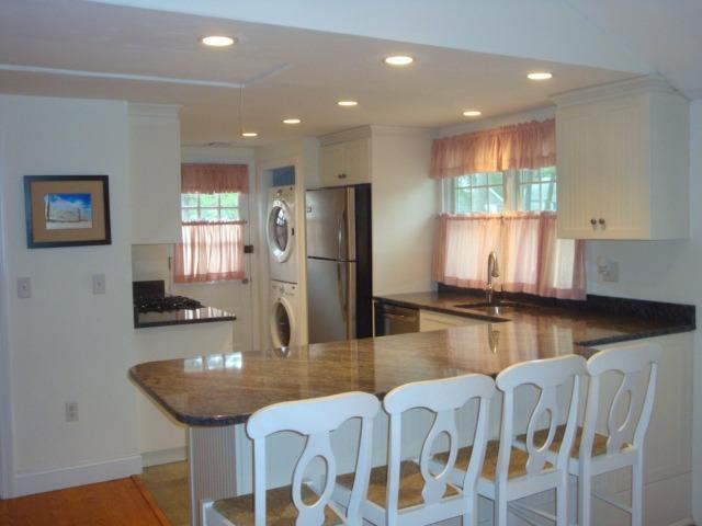 49 Lawrence Road Dennis Port, MA 02639 - Photo 6 of 14 a kitchen with stainless steel appliances granite countertop a kitchen island a stove a table and chairs