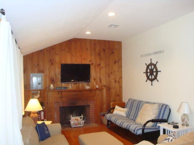 49 Lawrence Road Dennis Port, MA 02639 - Photo 7 of 14 a living room with furniture a flat screen tv and a fireplace