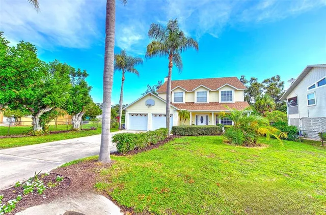 a view of a house with a yard and potted plants