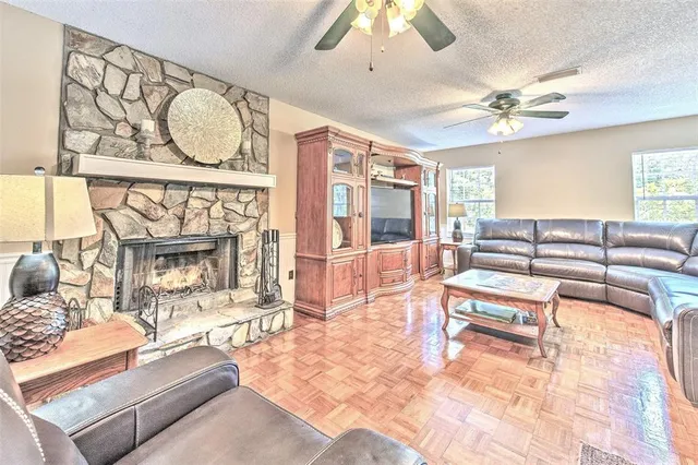 a living room with furniture a fireplace and a chandelier