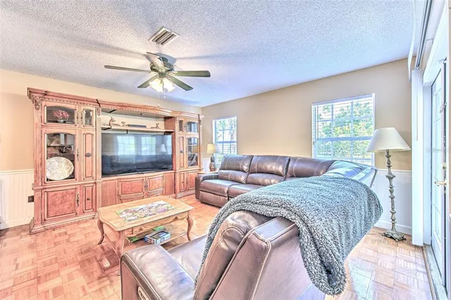 a living room with furniture a dining table and a piano table with wooden floor