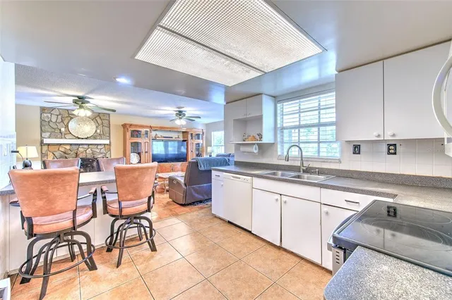 a large kitchen with kitchen island a large counter top space a sink stainless steel appliances and cabinets