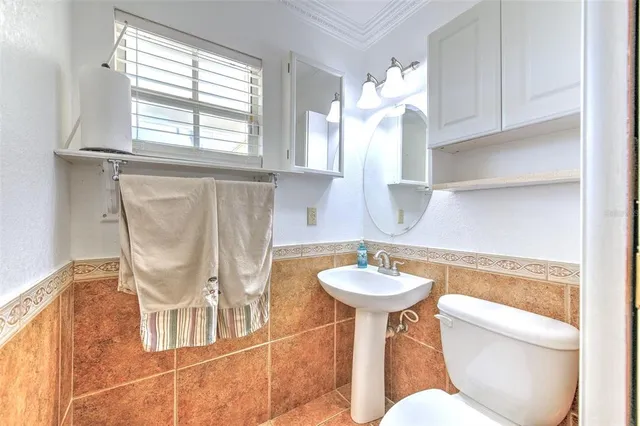 a view of a hallway to an empty room with wooden floor and a window